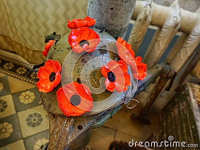 Military helmet painted with poppies in peace symbols. Stock Photo