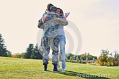 Military man father hugs daugther and wife. Stock Photo