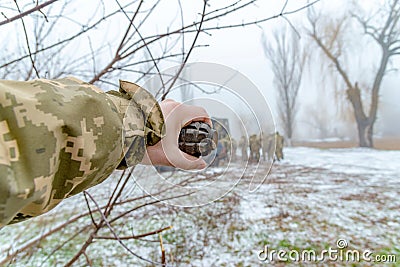 The military throws a fragmentation grenade with his hand Stock Photo