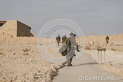 MILITARY TRAINING ZONE. Israeli soldiers walking through the territory of Masada fortification after war games. Masada Editorial Stock Photo