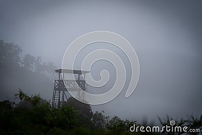 Military Wooden watch tower in the jungle surrounded by mystic fog. Dangerous concept Stock Photo