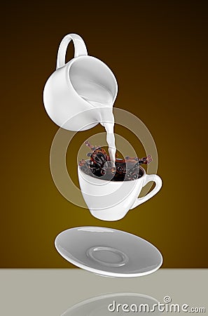 Milk being poured into small cup of coffee. 3d Stock Photo