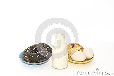 Milk, chocolate donuts, tart, eggs on white background Stock Photo