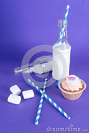 Milk cocktails with retro cocktail tubes, served in bottles on colourful background. Stock Photo