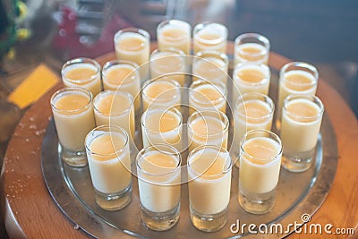 Milk cocktails in the small glasses on the tray at the table Stock Photo