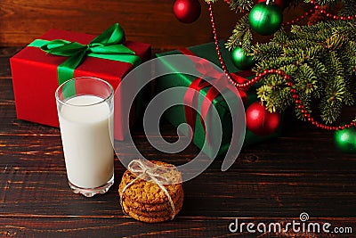 Milk, cookies and gifts under the Christmas tree. The concept of the arrival of Santa Claus Stock Photo