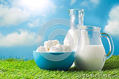 Milk and cottage cheese over meadow and blue sky background Stock Photo