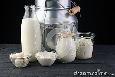 milk products - tasty healthy dairy products on a table on: sour cream in a white bowl, cottage cheese bowl, cream in a a bank and Stock Photo