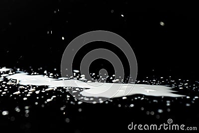 Milk spilled on black surface Stock Photo