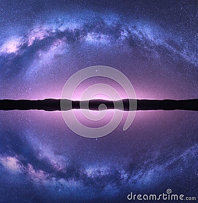 Milky Way arch reflected in water. Night landscape Stock Photo