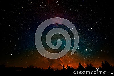 Milky way and fantasy galaxy clouds above the forest landscape, collage. Stock Photo