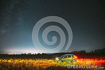 Milky Way Galaxy In Night Starry Sky With Glowing Stars Above Green Renault Duster SUV In Countryside Landscape. Milky Editorial Stock Photo