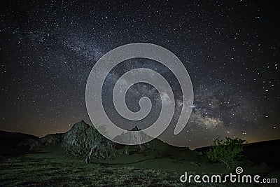 The Milky Way Galaxy rising above rocky landscape Stock Photo