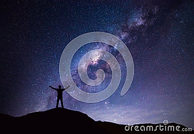 Milky Way landscape. Silhouette of Happy man standing on top of mountain with night sky and bright star on background Stock Photo