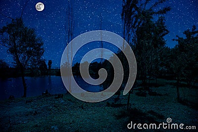 milky way over a lake at summer night with clear skies under moonlight Stock Photo