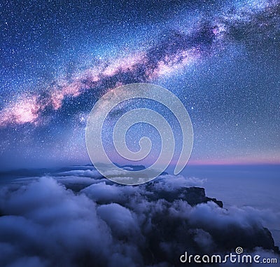 Milky Way over the low clouds and sea coast at starry night Stock Photo