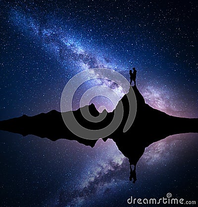Milky Way with silhouette of people on the mountain Stock Photo