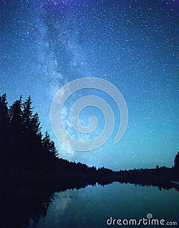 Milky Way Stars Over Forest and Lake Stock Photo