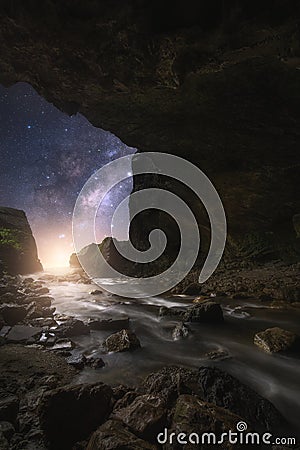 The Milky Way towering above the moonlight waterfall,Landscape of stream that flows from the cave to the waterfall with beautiful Stock Photo