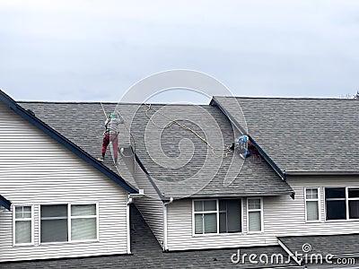 Mill Creek, WA USA - circa March 2023: Wide view of roofers working to repair roof materials in an apartment complex on an Editorial Stock Photo