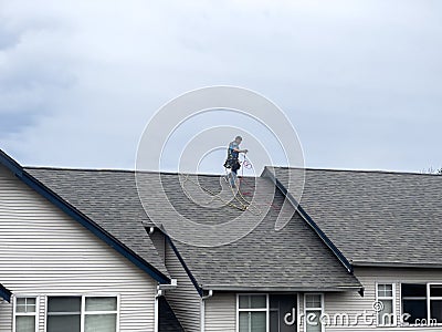 Mill Creek, WA USA - circa March 2023: Wide view of roofers working to repair roof materials in an apartment complex on an Editorial Stock Photo