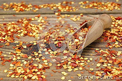 Milled Chili Peppers Flakes And Corns On Wooden Board Stock Photo