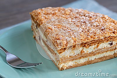 Millefoglie or mille-feuille pastry on a plate, powdered sugar Stock Photo