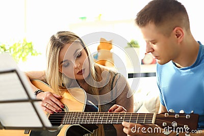 Millenial woman and guitar teacher play music Stock Photo