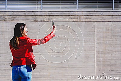 Millenial woman taking a selfie with happy gesture to pretend to be successful in life Stock Photo