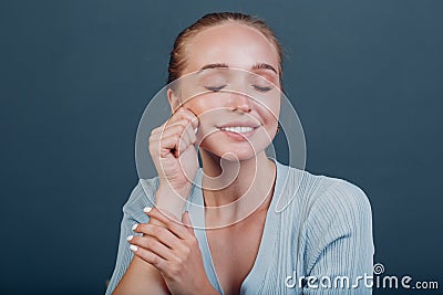 Millenial young woman blonde hair portrait doing face yoga self facebuilding massage for face skin Stock Photo