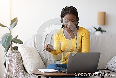 Millennial African Lady In Headset Watching Online Webinar On Laptop At Home Stock Photo