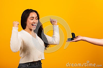 Millennial arab guy hand giving ring box to satisfied excited woman with open mouth Stock Photo