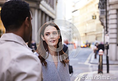 Millennial business colleagues standing on a street in London having a conversation, close up Stock Photo