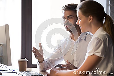 Colleagues negotiate looking at computer in office Stock Photo