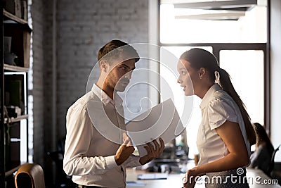 Diverse employees argue over financial report in office Stock Photo