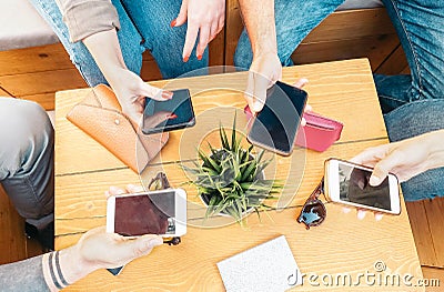 Millennial friends using their mobile smart phones in bar - Young people connecting on new trends social networks Stock Photo