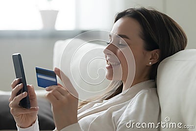 Millennial girl shopping on cellphone using credit card Stock Photo