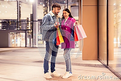 Millennial husband surprises his wife with little wrapped box outside Stock Photo