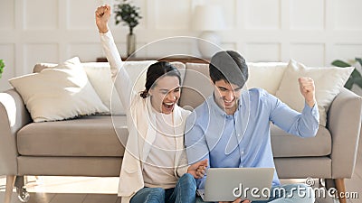 Millennial husband and wife sport fans enjoying game at home Stock Photo