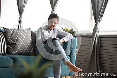 Millennial indian girl using modern tablet gadget at home Stock Photo