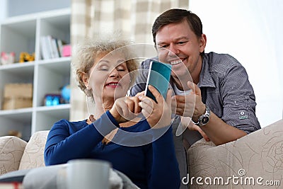 Millennial son helps an adult listen mother Stock Photo