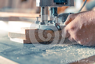 Milling wood in the joinery using manual mechanical cutters. Flying sawdust in the air Stock Photo