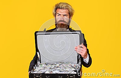 Millionaire. Serious man with suitcase full of money. Serious businessman with briefcase of dollars. Stock Photo