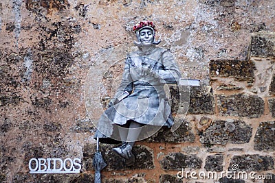 Mime actress interpreting a statue in the Portuguese village of Obidos. Editorial Stock Photo