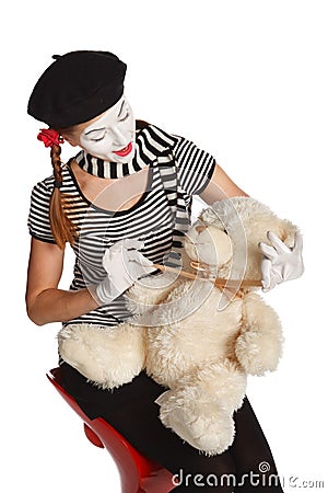 Mime comedian playing with teddy bear Stock Photo