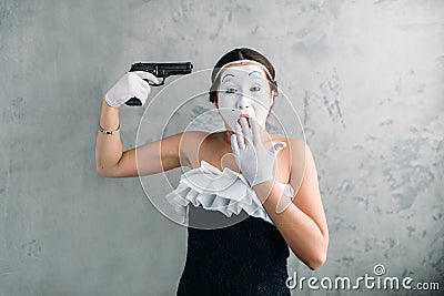 Mime female artist performing with gun Stock Photo