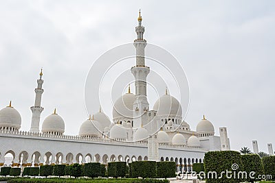 Minaret and domes of white Grand Mosque against white cloudy sky, also called Sheikh Zayed Grand Mosque, inspired by Persian, Editorial Stock Photo