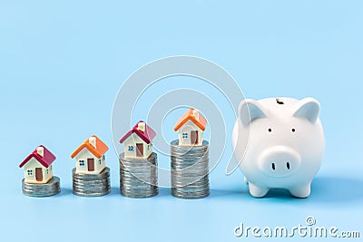 Minature houses resting on coin stacks, concept for property ladder, mortgage and real estate investment Stock Photo