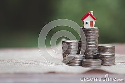 Minature houses resting on coin stacks, concept for property ladder, mortgage and real estate investment Stock Photo