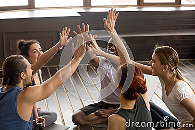 Mindful happy sporty diverse people joining hands at group semin Stock Photo